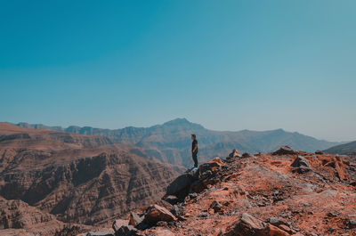 Man on rock against sky