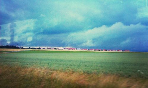 Scenic view of field against cloudy sky