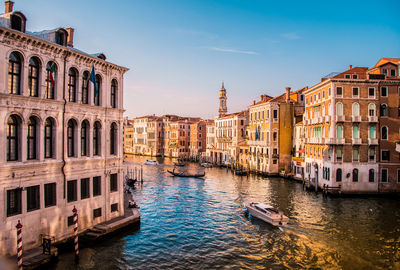 Boats in canal amidst buildings in city