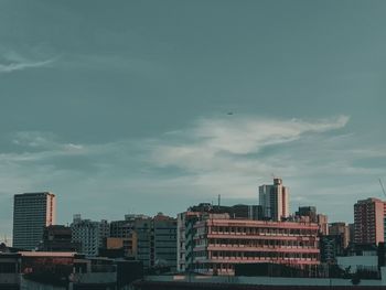 Buildings in city against sky during sunset