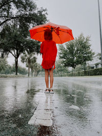 A girl is standing with umbrella under the rain