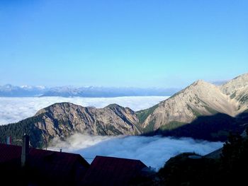 Scenic view of snowcapped mountains against blue sky