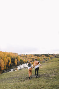 Happy people in love are travel hike in nature in the autumn forest. romantic trip to countryside