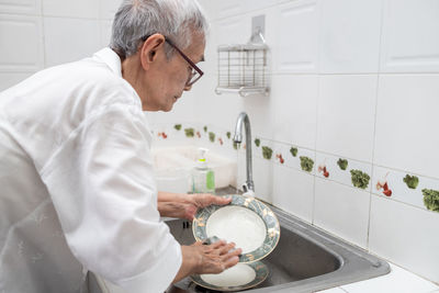 Side view of man working in kitchen