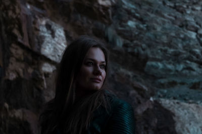 Portrait of beautiful young woman standing on rock