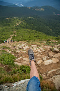 Low section of man sitting on mountain