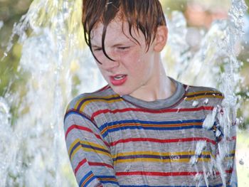 Close-up of boy standing amidst water