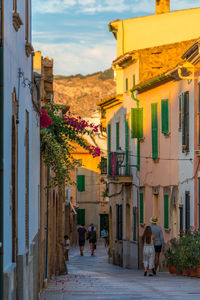 People walking on street amidst buildings in city