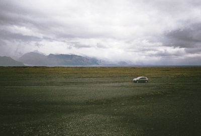 Scenic view of field against cloudy sky