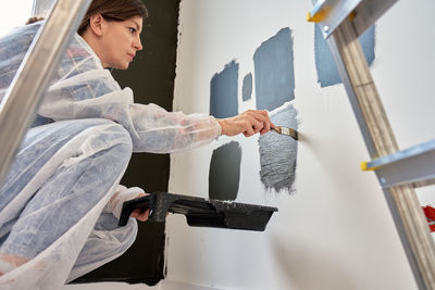 Side view of young woman using mobile phone