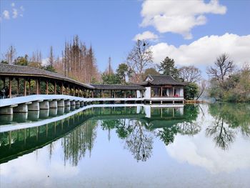 Arch bridge over lake by building against sky