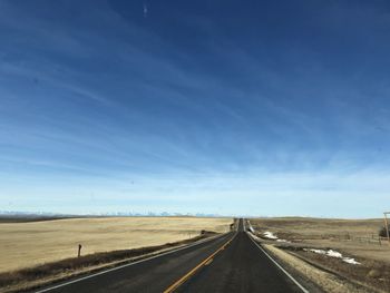 Empty road along countryside landscape