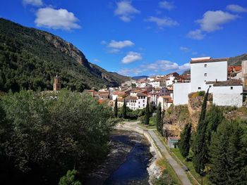 Road amidst buildings in town against sky