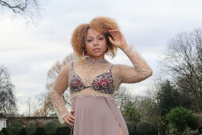 Portrait of woman in dress standing against sky