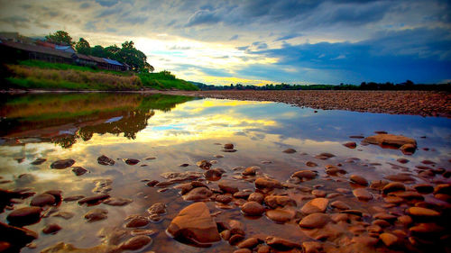 Scenic view of river against cloudy sky