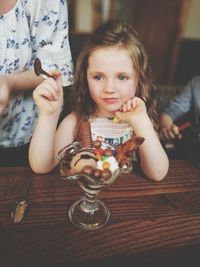 Girl looking away while having ice cream at table