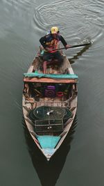 High angle view of man sailing fishing boat in lake