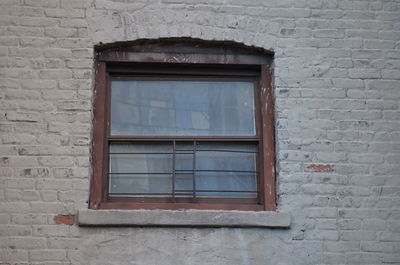 Low angle view of window on brick wall