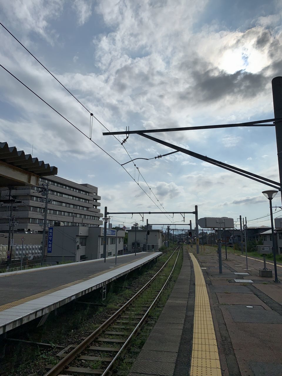 RAILROAD TRACKS AGAINST CLOUDY SKY