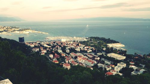 High angle view of cityscape by sea against sky