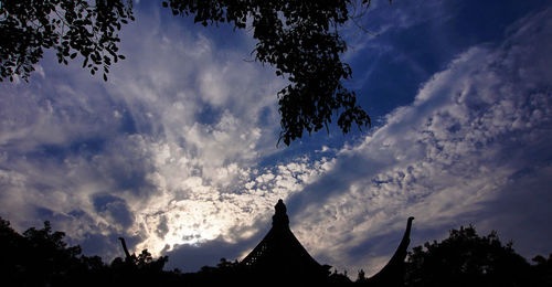 Low angle view of silhouette trees against sky