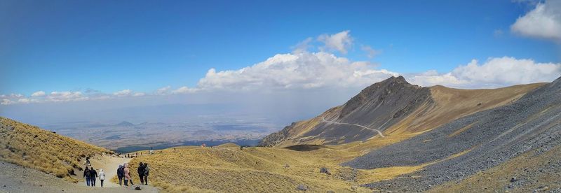 Panoramic view of people on mountain against sky