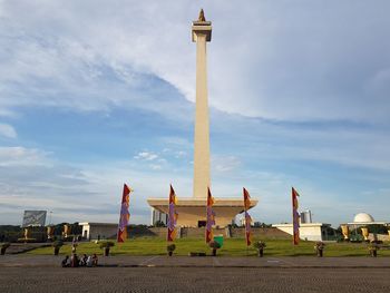 People at historical building against sky