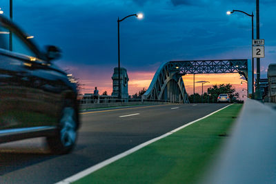 Cars on road against sky in city