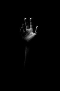 Close-up of human hand against black background