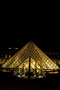 Low angle view of illuminated building against sky at night