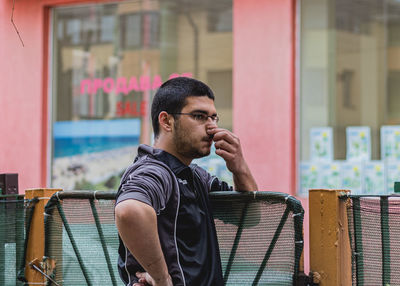 Portrait of young man sitting in city