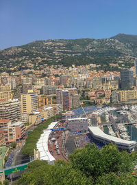 High angle view of buildings in city against clear blue sky