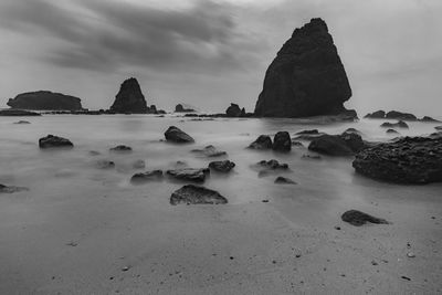 Rocks on beach against sky