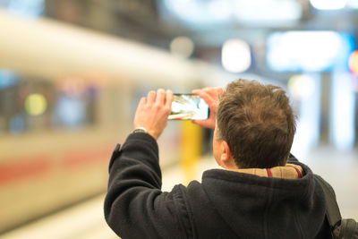 Rear view of man using mobile phone