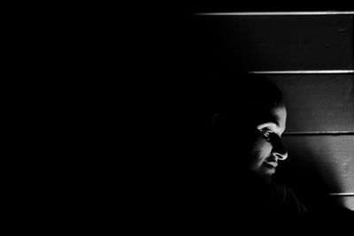 Close-up of woman looking down in darkroom