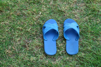 High angle view of blue sandals shoes on green grass field