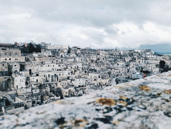 High angle view of buildings in town against cloudy sky