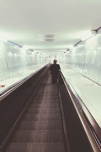Rear view of man on escalator