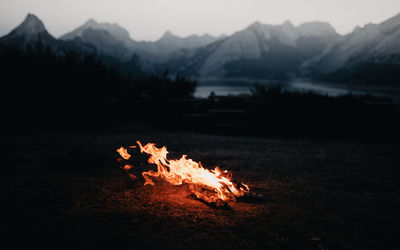 Bonfire on field against mountain range