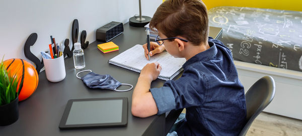 High angle view of boy studying at home