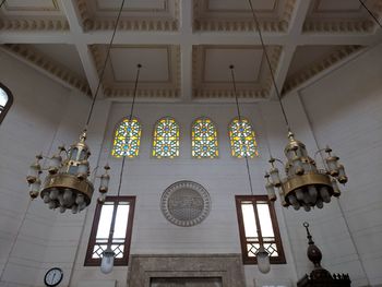 Low angle view of illuminated chandelier hanging in building