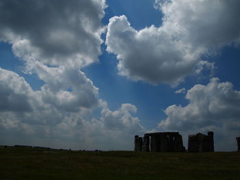 Built structure on field against cloudy sky