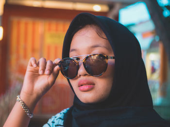 Close-up portrait of young woman wearing sunglasses