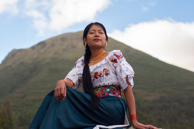 Portrait of young woman sitting on mountain