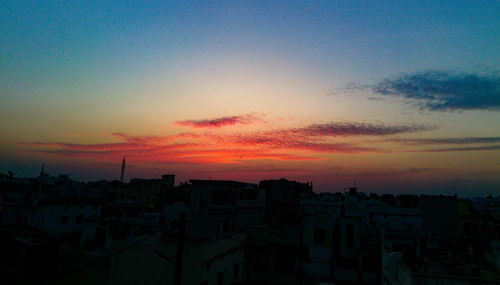 Silhouette cityscape against sky during sunset