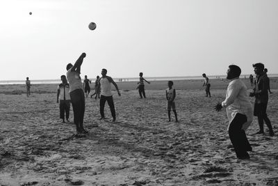 People playing with ball on beach