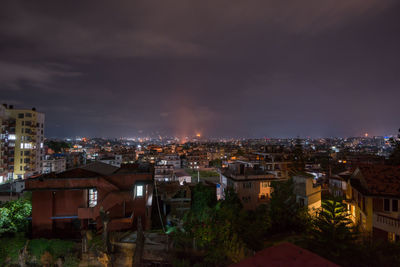Illuminated cityscape against sky at night
