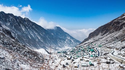 Scenic view of snowcapped mountains against blue sky