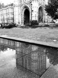 Reflection of building in puddle on street