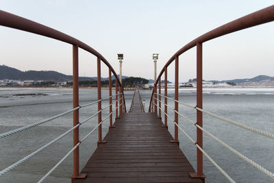 Pier over sea against clear sky